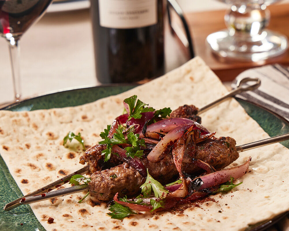 Grilled Harissa Spiced Lamb Kebabs with Red Onion Salad, Pomegranate Molasses and Sumac